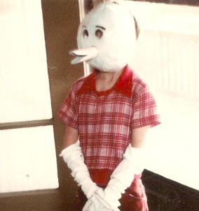  I looked through *all* the photo albums, and, astonishingly, this is the only photo of a school project that I can find. This one is for a book report. The main character (some kind of animal) wanted to be a duck and so made himself a duck costume. Kevin thought that a duck costume would be a fine book report project. You can't see his feet, which I think have orange duck feet on top of them. Hands and feet and face were the costume elements of the story's main character. Kevin's duck mask is paper mache (recycled newspaper). The bill is, of course, crafted from cardboard paper towel tubes.